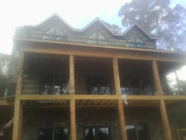 Dormers and porch framing on a large log home under construction — Roof Coating work by our crew in Grapevine